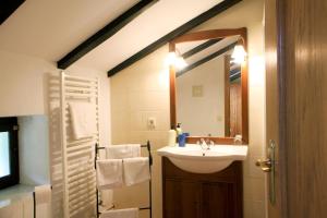 ein Bad mit einem Waschbecken und einem Spiegel in der Unterkunft Casa Rural Malkornea in Maya del Baztán