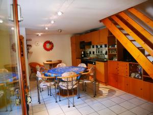 Una cocina con una mesa y sillas en una cocina. en Lagon 173 - Maison de Vacances - 3 Chambres, en Gruissan