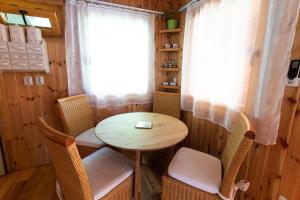 ein kleiner Tisch und Stühle in einem Zimmer mit Fenster in der Unterkunft Barna Faház in Tarnaszentmária