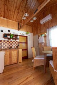 eine Küche mit Holzdecken sowie einem Tisch und Stühlen in der Unterkunft Barna Faház in Tarnaszentmária