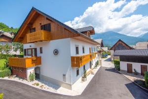 a house with wooden balconies on a street at Tourist Farm "Pri Biscu" in Bled