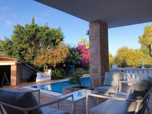 un patio con sillas y una piscina en Villa con piscina gigante, en Sant Francesc de s'Estany