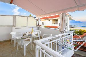 a balcony with a table and chairs and the ocean at Billy's House in Sarti