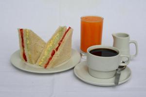 a plate with a sandwich and a cup of coffee at Hotel Bracamonte in Huanchaco