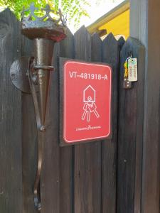 un panneau rouge sur une clôture avec une personne tenant une porte dans l'établissement MAEVA PLAYA BUNGALOW, à El Campello