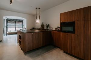 Una cocina con gabinetes de madera y microondas. en Jolie Logie, en Nieuwpoort