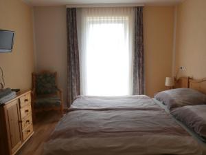 Schlafzimmer mit einem Bett und einem Fenster mit einem Stuhl in der Unterkunft Ferienwohnung Bluemelhube Wohnung Elisabeth in Vordernberg