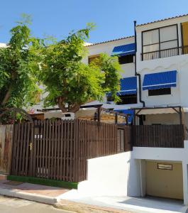 a building with a wooden fence and a tree at MAEVA PLAYA BUNGALOW in El Campello