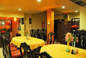 a dining room with two tables and chairs with flowers on them at Guruvayoor Resort in Guruvāyūr