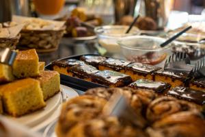 a table topped with different types of pastries and bread at Pousada Recanto da Mata in Marechal Floriano