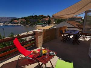 un patio con tavolo e sedie sul balcone. di Apartments Lumbardina a Lumbarda (Lombarda)