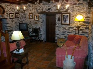 a living room with two chairs and a tv at Casa de Aldea Rural Los Glayus in Luarca