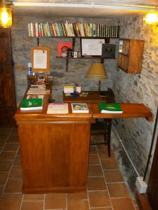 un escritorio de madera con una lámpara y libros en la pared en Casa de Aldea Rural Los Glayus, en Luarca