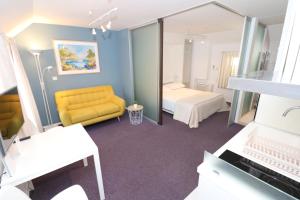 une chambre d'hôtel avec un canapé jaune et un miroir dans l'établissement Miró Studio Apartments Dubrovnik, à Dubrovnik
