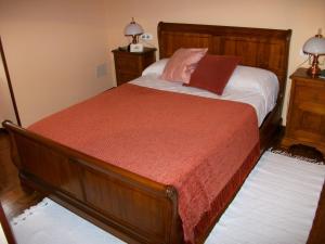 a bedroom with a bed and two night stands and two lamps at Casa de Aldea Rural Los Glayus in Luarca