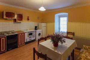 una cocina con mesa y una cocina con mesa y sillas en Apartman Gržin, en Mošćenička Draga 13 fotos más