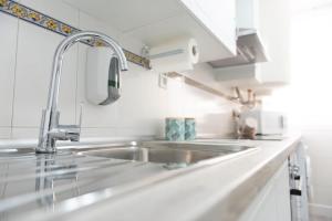 a kitchen with a stainless steel sink and white cabinets at Casa Teresa in Cenes de la Vega +52 photos