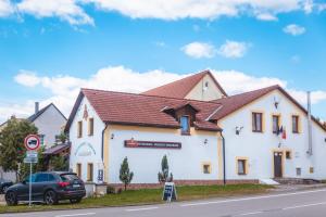 a white building with a brown roof at Penzion Samorost in Jarošov nad Nežárkou