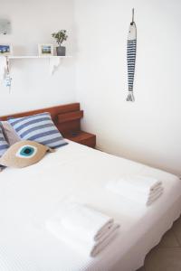 a bed with white sheets and a fish on the wall at Skiathos Town House in Skiathos