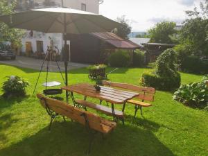 a table and benches with an umbrella in a yard at Pokoje Gościnne Skalny Agroturystyka in Żabnica +5 photos
