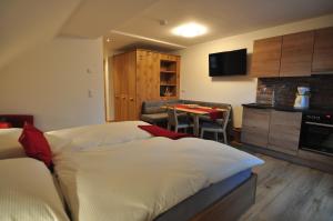 a bedroom with a bed and a kitchen with a table at Haus Garz in Weissensee