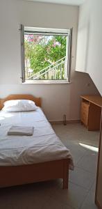 a bedroom with a bed and a large window at Nera Apartment in Brodarica
