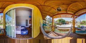 um quarto com uma cama e um baloiço numa varanda em Alma Brava em Itajaí
