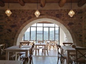 un ristorante con tavoli e sedie e una grande finestra di La Casa della Filanda a Belmonte Calabro
