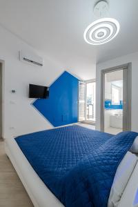 ein blau-weißes Schlafzimmer mit einem großen Bett in der Unterkunft Bali - BeDreams in Gaeta