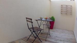 a small table with a chair next to a wall at Joli petit studio près du phare in Calais