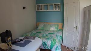 a bedroom with a bed and a desk with a computer at Joli petit studio près du phare in Calais