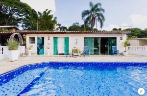 une villa avec une piscine en face d'une maison dans l'établissement Cantinho Romântico e Encantador, à Mairiporã