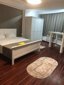 Schlafzimmer mit einem Bett, einem Tisch und einem Teppich in der Unterkunft Pensiunea Pont-Euxin in Constanţa