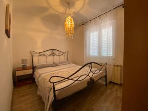 1 dormitorio con cama, ventana y lámpara de araña en Apartments Tajana en Novigrad Istria