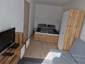 a small bedroom with a bed and a television at Sweet Life Apartman in Eger