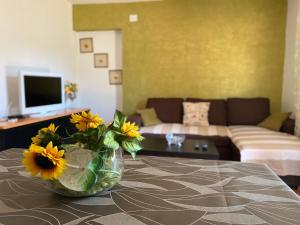 een woonkamer met een vaas met zonnebloemen op een tafel bij Apartments Tajana in Novigrad Istria