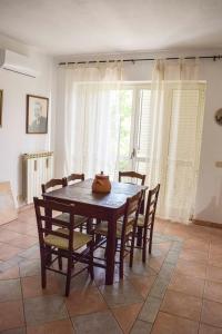 Affittacamere D'amore في Foria: غرفة طعام مع طاولة وكراسي خشبية