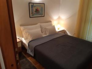 een kleine slaapkamer met een bed met 2 kussens bij Apartments Magdalena in Pag