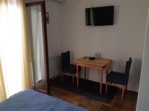 a bedroom with a desk with two chairs and a television at Apartments Magdalena in Pag