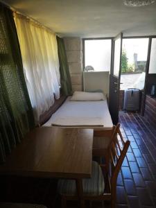 a room with a table and a bed and a table and a bench at APP-AMELIJAS in Zambratija