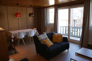 a living room with a couch and a table with a view at Belle Villa in De Panne