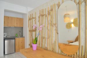 a kitchen with a mirror and a vase with flowers at Hotel Apartments Giannis in Adamantas
