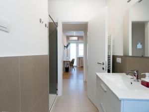 bagno bianco con lavandino e doccia di Maison Altinia a Treviso