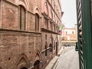 un edificio di mattoni con una bandiera sul lato di B&B Quattro Cantoni a Siena