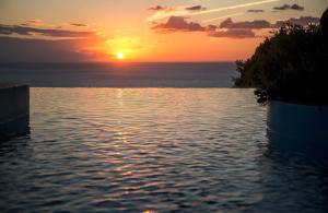 a sunset over a body of water with the ocean at Boutique Hotel Torre Di Cala Piccola in Porto Santo Stefano