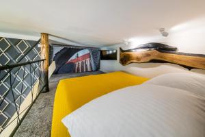 クラクフにあるStudio z ogrodem przy Starej Zajezdniの大きなベッドと絵画が飾られた壁が備わるベッドルーム1室が備わります。