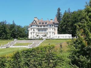 a large house on top of a green field at Chambre dans Maison Campagnarde in Présilly