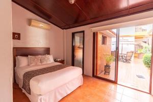 1 dormitorio con 1 cama y puerta corredera de cristal en Hotel Doña Juana, en Tlacotalpan