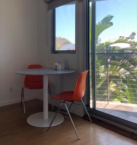 a table and two chairs in a room with a window at The M Malibu in Malibu