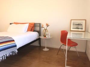 1 dormitorio con cama, escritorio y silla en The M Malibu, en Malibú